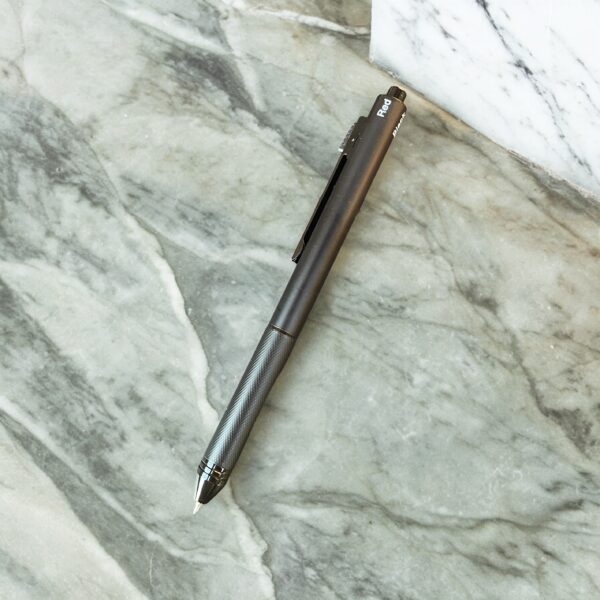 Black multi-functional pen lying on a grey marble desk.